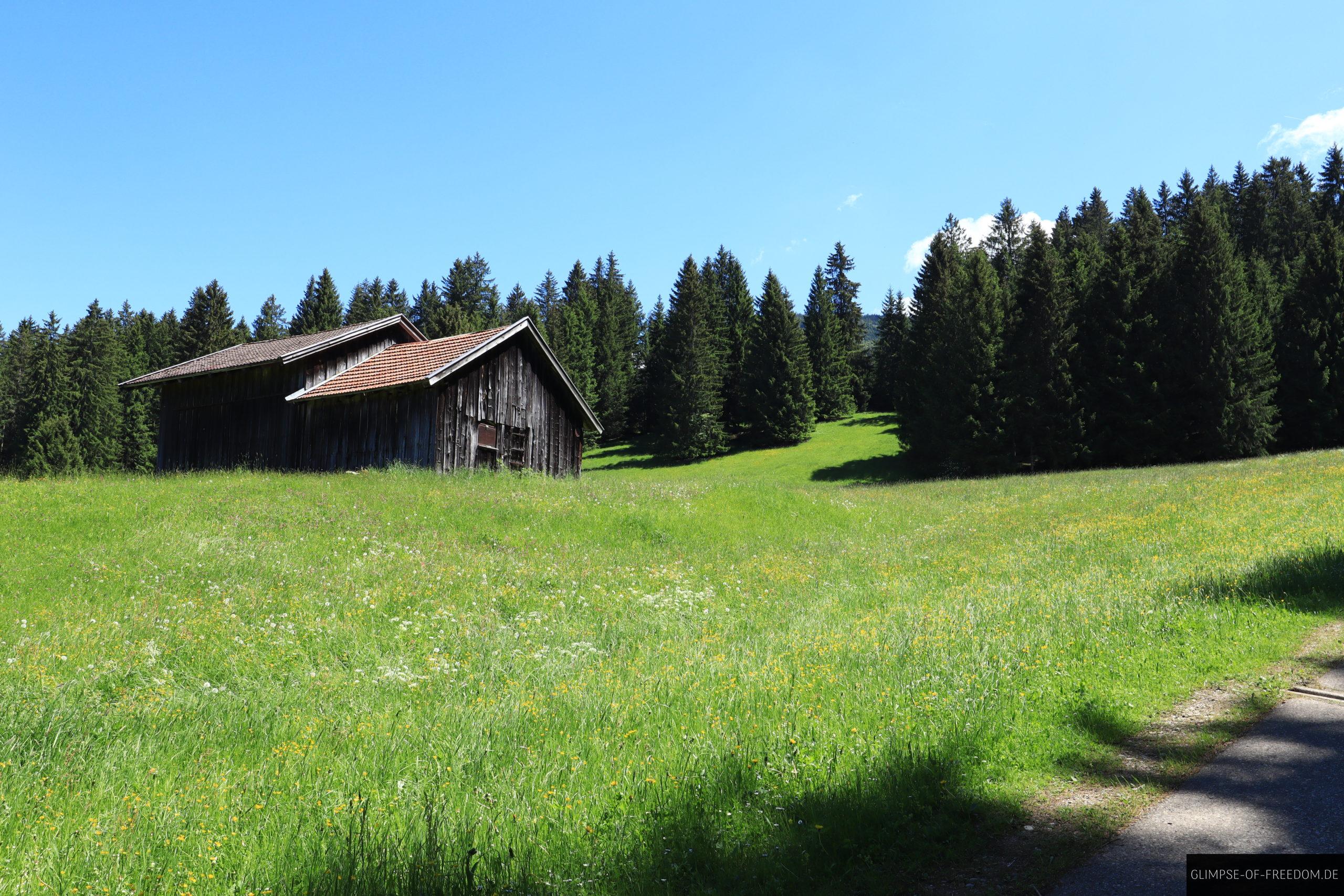 Huette auf der Wiese zu Beginn der Sonnenkopf Wanderung scaled Hütte auf der Wiese zu Beginn der Sonnenkopf Wanderung