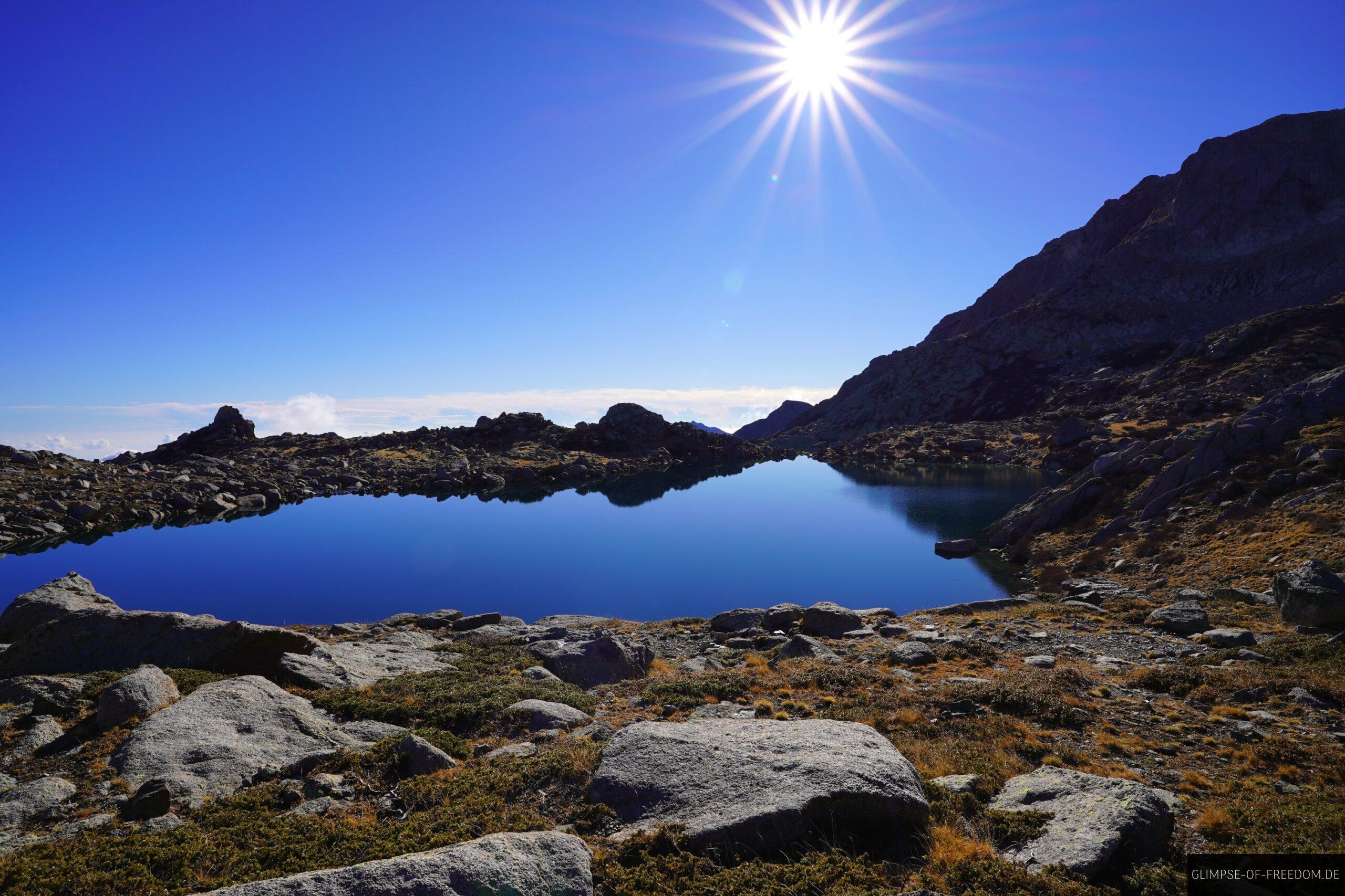 bergsee am felsufer mit sonne im bild scaled Bergplick mit sonne im bild