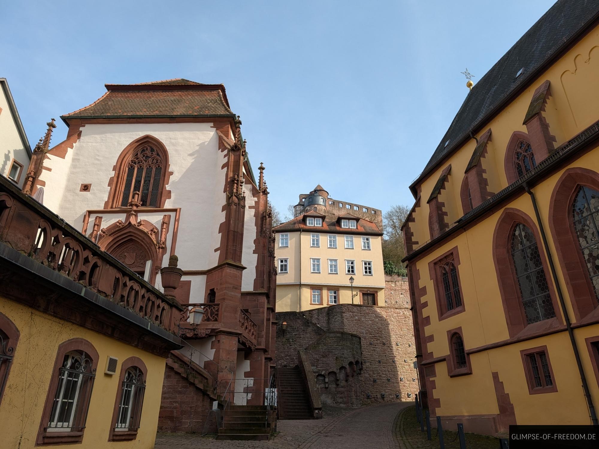 burg wertheim architektur gebaeude sandstein Burg Wertheim Architektur: Blick auf Gebäude mit rotem Sandstein und gelben Fassaden unter blauem Himmel.