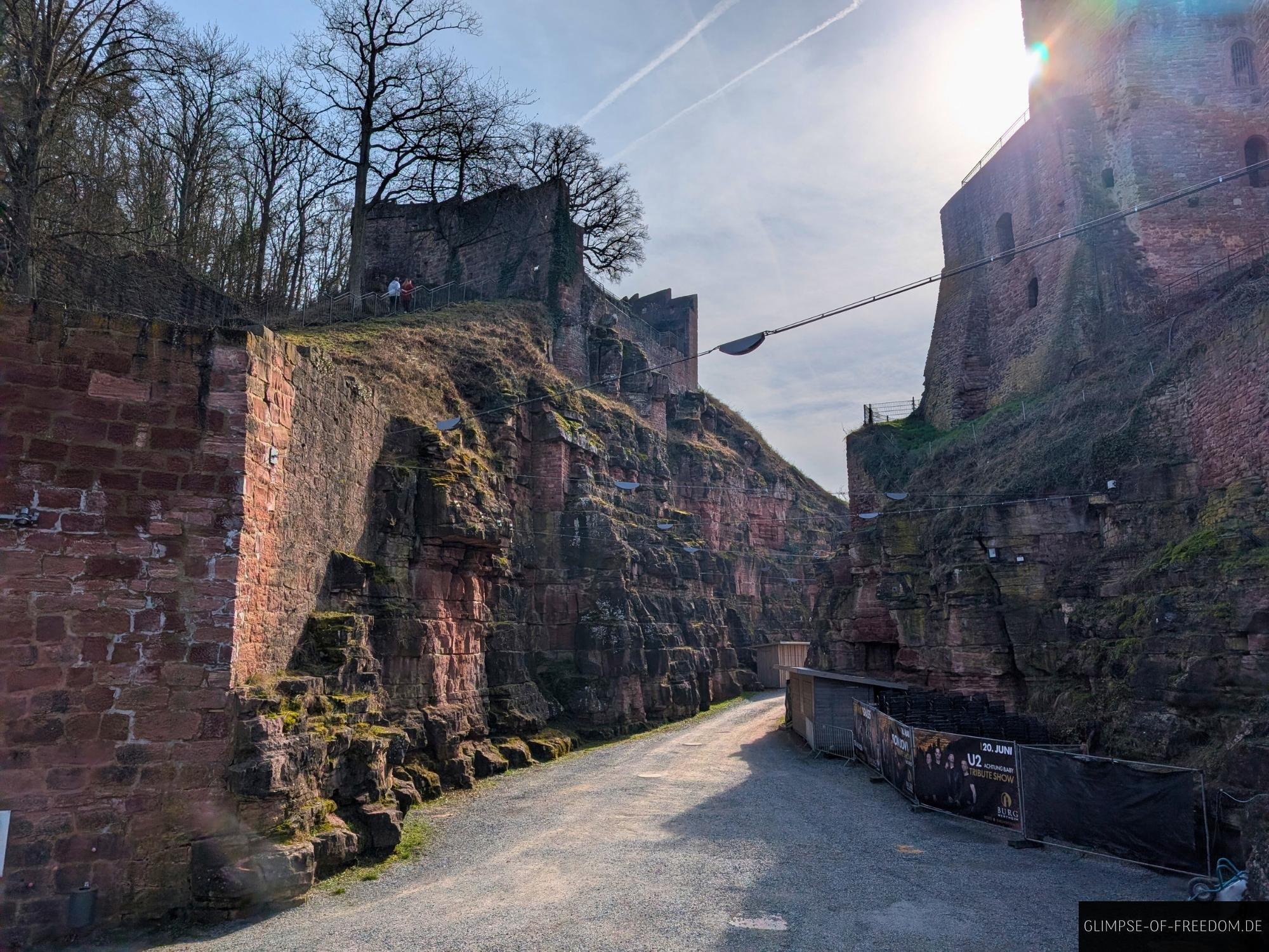 burg wertheim ruine burggraben weg Burg Wertheim Ruine: Blick durch den Burggraben mit Mauern und Weg an einem sonnigen Tag.