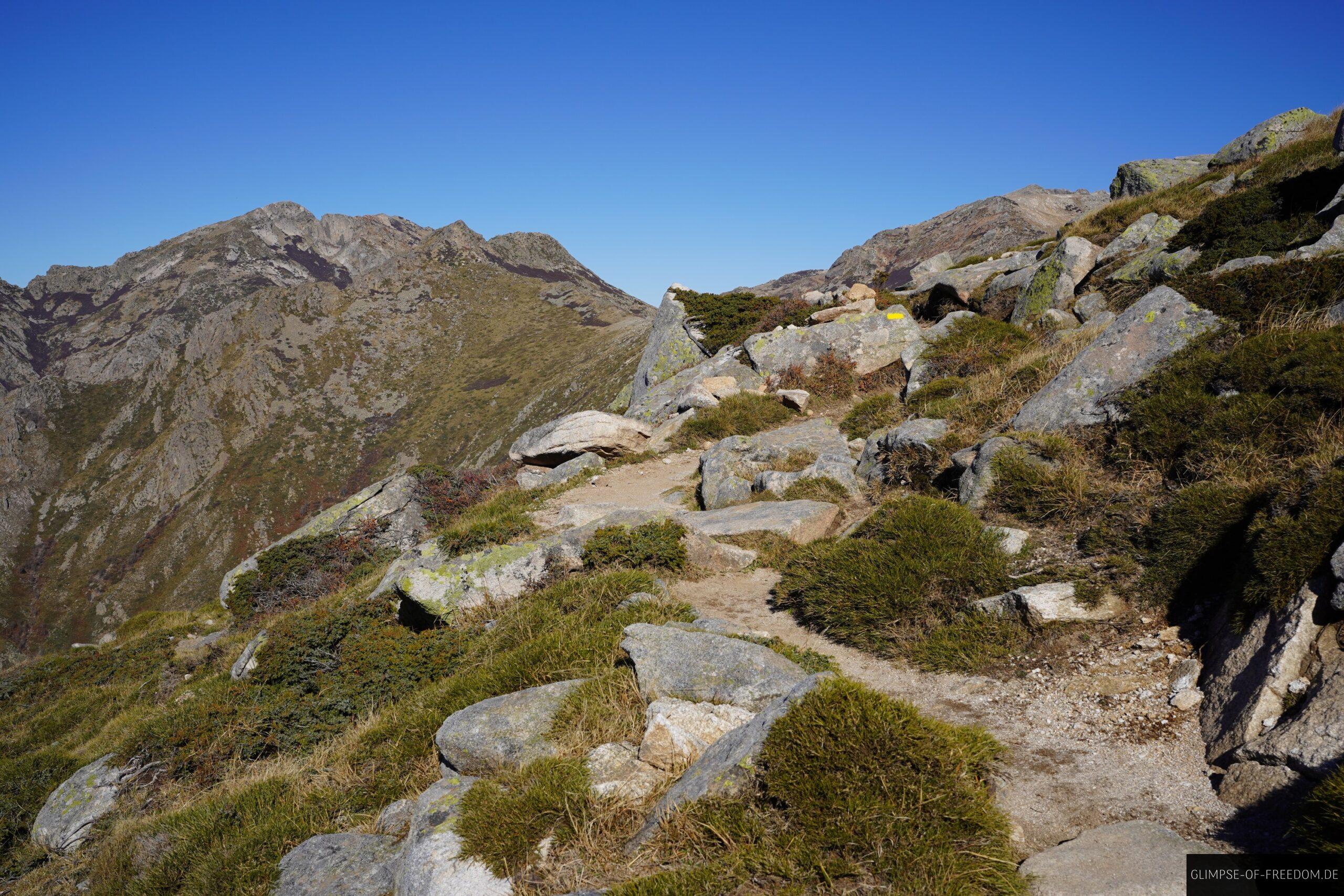korsika wanderweg bergpfad felsen panorama scaled Korsika Wanderweg: Bergpfad mit Felsen und Blick auf Bergpanorama. Pozzi Seen Wanderung.