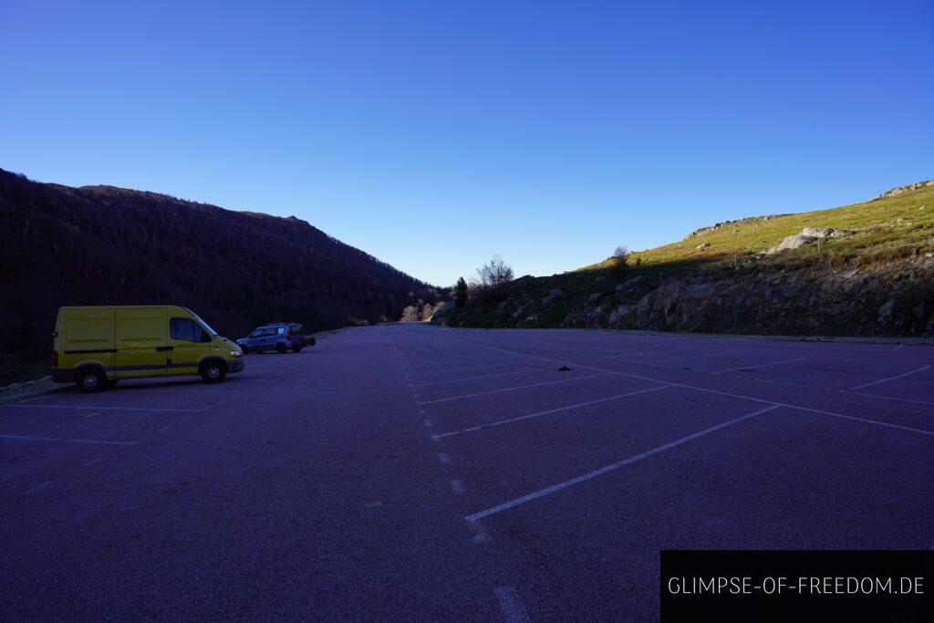 Parkplatz in Korsika mit gelbem Van und Blick auf Berge. Wanderung Pozzi Seen im Hintergrund. Parkplatz in Korsika mit gelbem Van und Blick auf Berge. Wanderung Pozzi Seen im Hintergrund.
